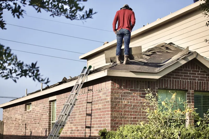 Professional roofer working on a residential roof in Lamplight Village